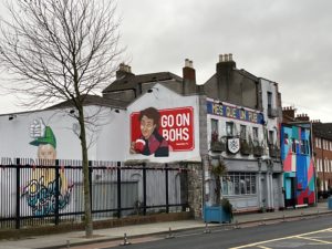 Exterior of The Back Page, with Mrs Doyle saying 'Go on, Bohs'